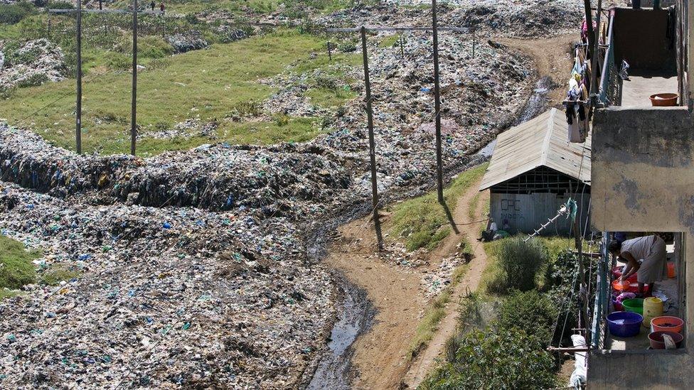 A woman washes her clothes near a rubbish dump in Nairobi, Kenya.