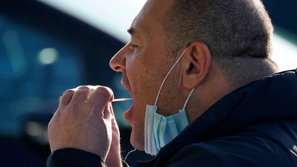 A man self-administering a coronavirus test