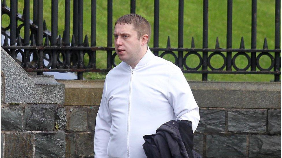 Domonic O'Connor walking, wearing a white shirt and holding a black jacket in left hand