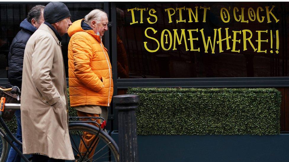 Men walking past bar