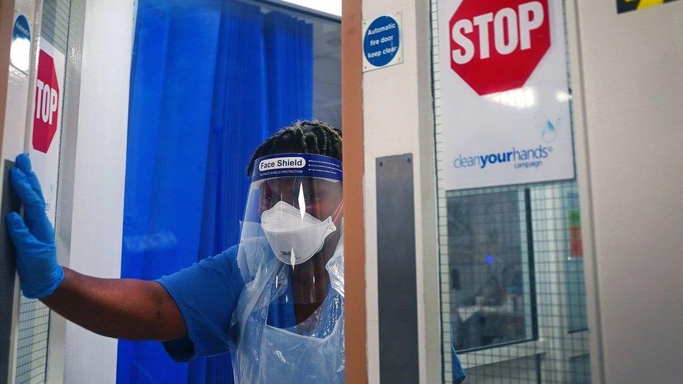 A member of staff wearing PPE walks through a ward for Covid patients at King"s College Hospital, in south east London