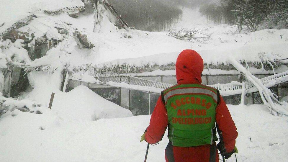 A rescuer looks at the ruins of the Rigopiano hotel, 19 january