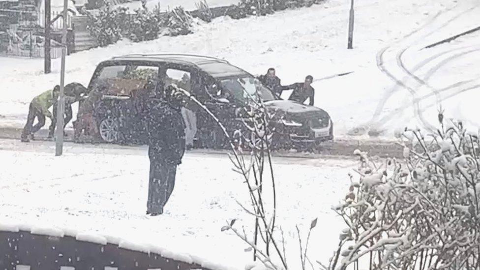 Hearse being pushed through snow