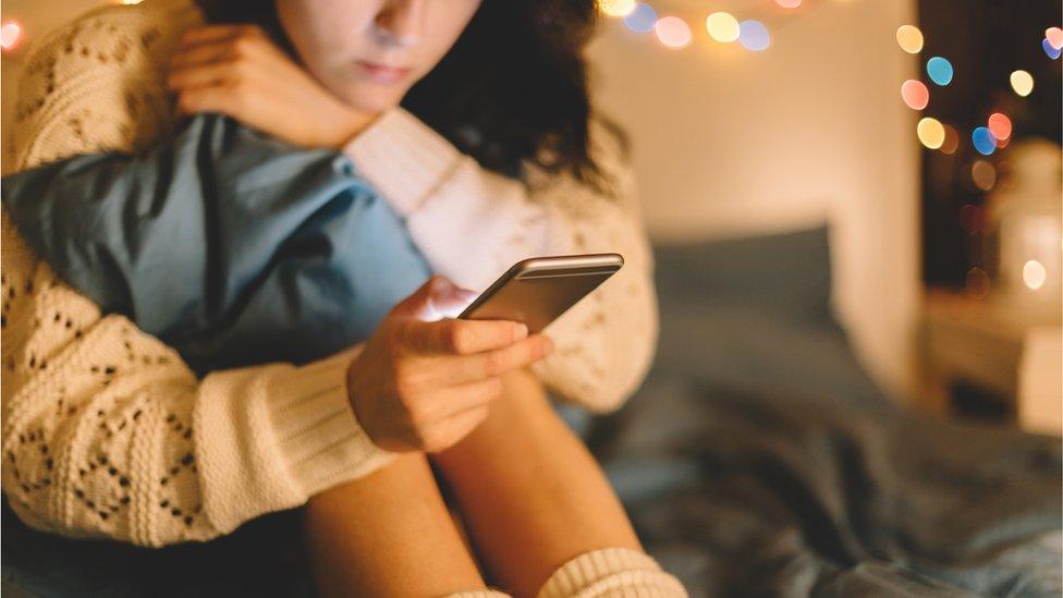 Woman on phone in bed