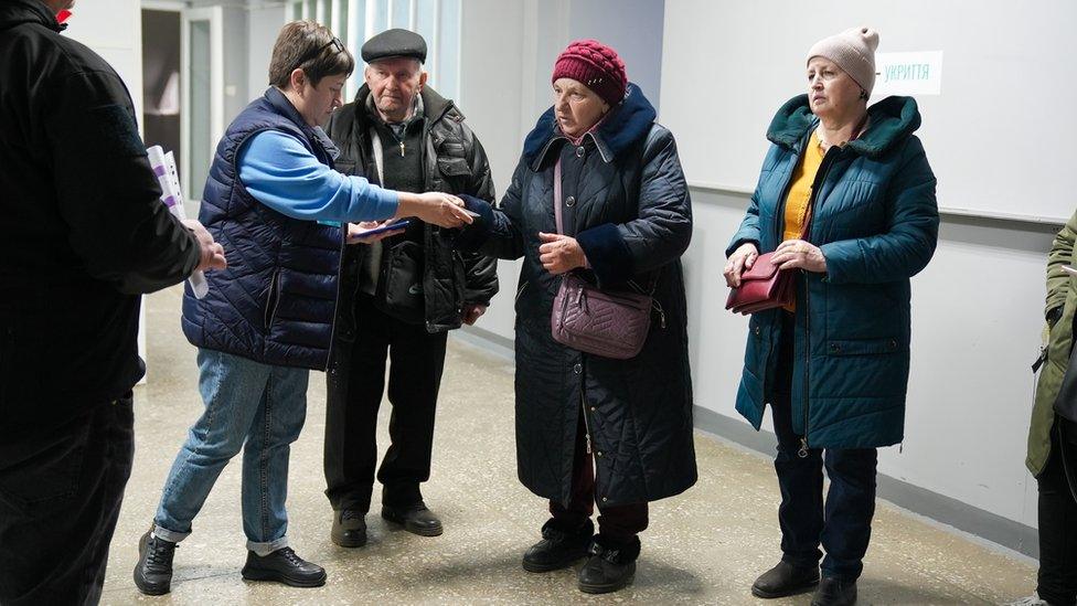 Zoya and her husband Mykhailo show their documents at the reception centre