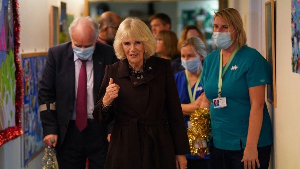 The Queen walks down a hallway in the hospice