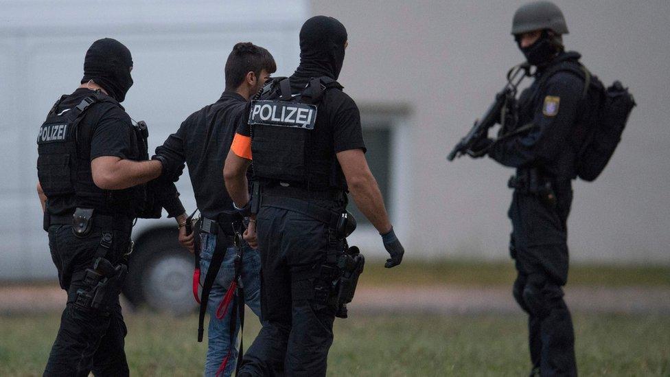 Police officers wearing balaclavas escort Iraqi asylum seeker Ali Bashar at the police headquarters in Wiesbaden, western Germany on 9 June 2018.