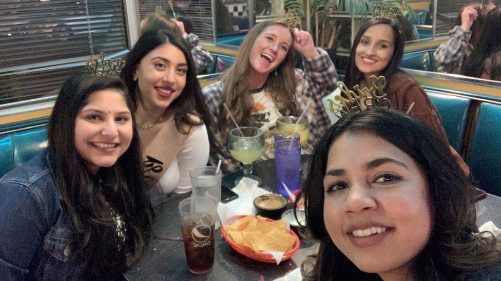 Five girls smiling at a restaurant