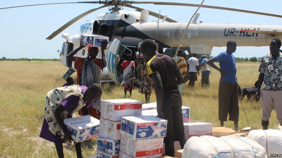 Women collect food supplies from a United Nations helicopter