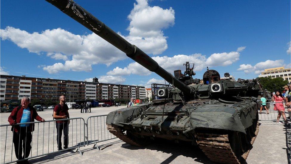 People look at a Russian tank on display in Prague