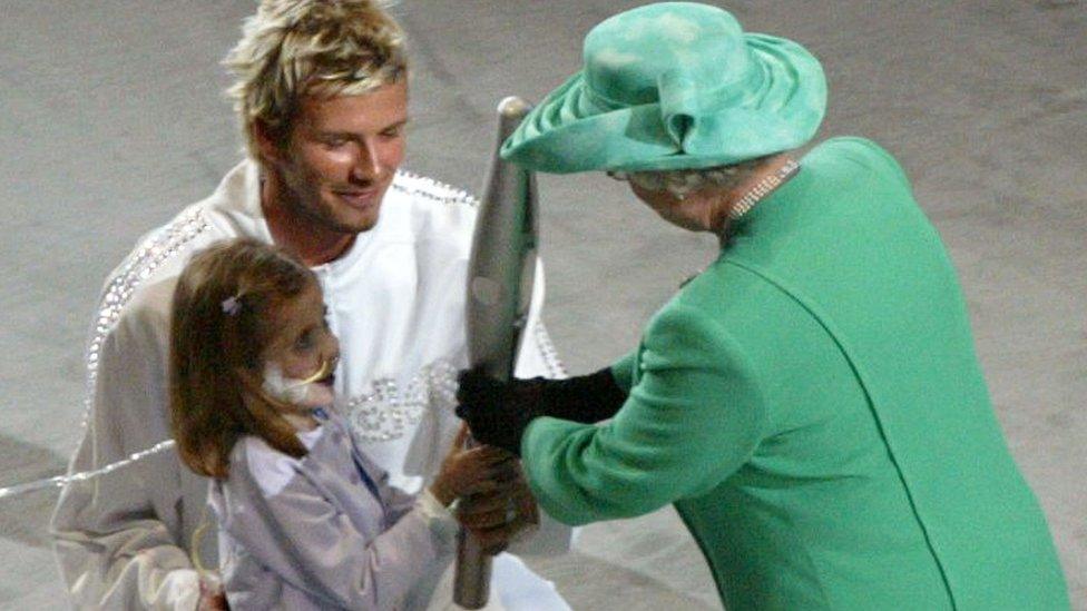 The Queen receives the Commonwealth Games baton in Manchester in 2002.