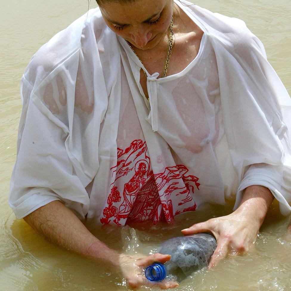 Russian woman filling water bottle