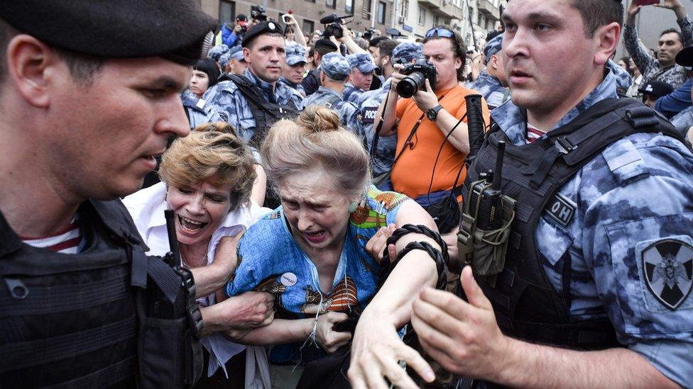 Russian police officers detain protesters during a march to protest against the alleged impunity of law enforcement agencies in central Moscow on June 12, 2019