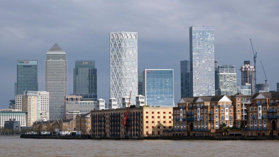 Canary Wharf skyline, showing various skyscrapers, housing and some cranes.