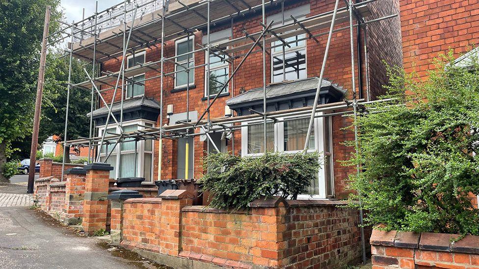 A street view of the terrace house with scaffolding on the outside