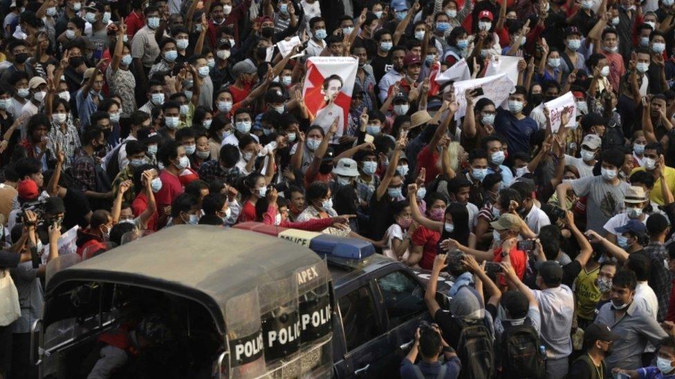 A police vehicle makes its way through a demonstration against the military coup, in Yangon, Myanmar