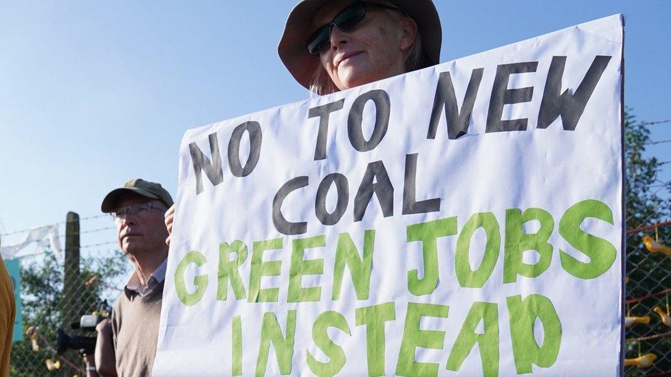 Woman holds sign