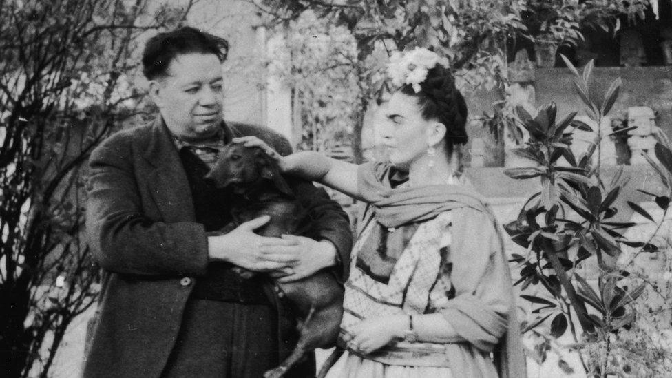 Mexican painters Frida Kahlo (1907 - 1954) and Diego Rivera (1886 - 1957) stand together with a pet dog in Mexico City, Mexico, in the 1940s.