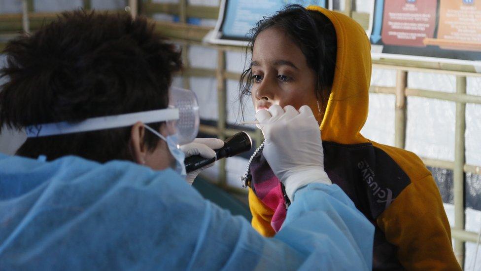 British nurse Becky Platt examines a young girl with suspected diptheria