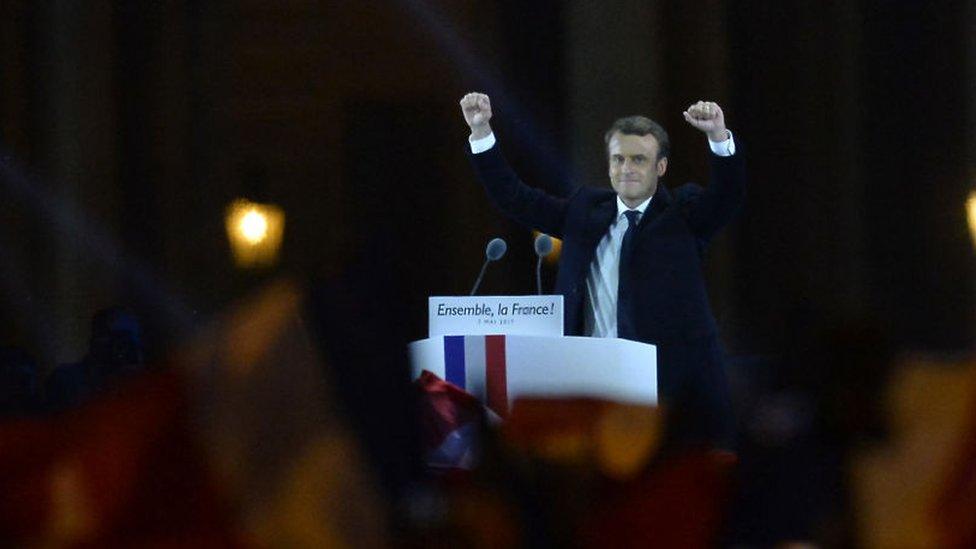 Emmanuel Macron salutes voters after his speech as he celebrates his presidential election victory