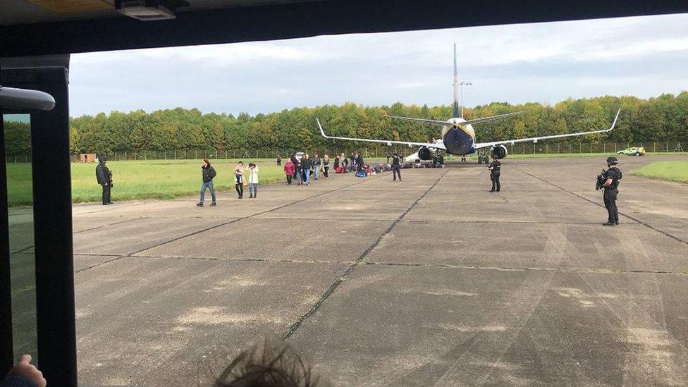 Passengers leave the plane that was escorted to Stansted