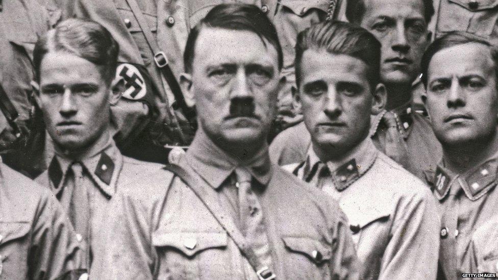 Adolf Hitler standing in front of other men