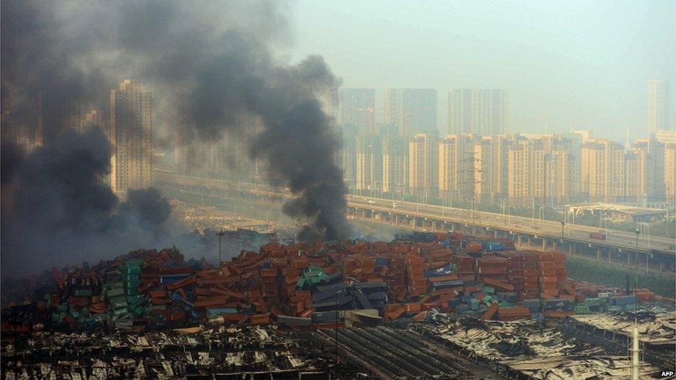 Fire and smoke rise at the site of the massive explosions in Tianjin on 13 August 2015