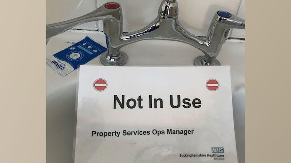 A basin at Wycombe General Hospital with a sign resting on it saying "not in use"