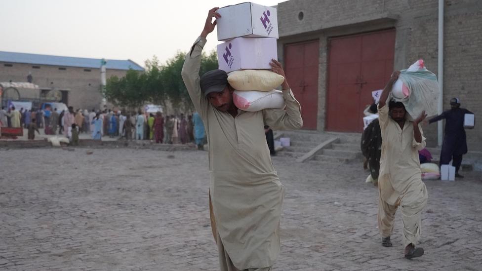 Men carrying aid supplies in Pakistan