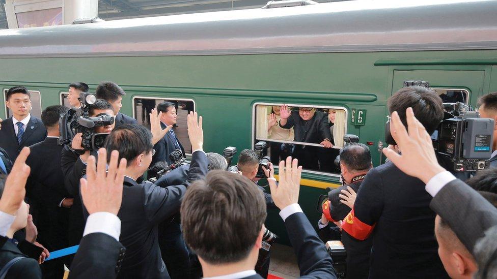 North Korean leader Kim Jong-un waves from a train during his visit to China