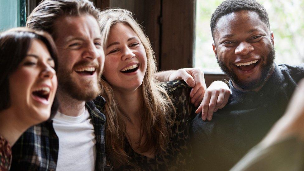 Crowd of friends socialising in a pub