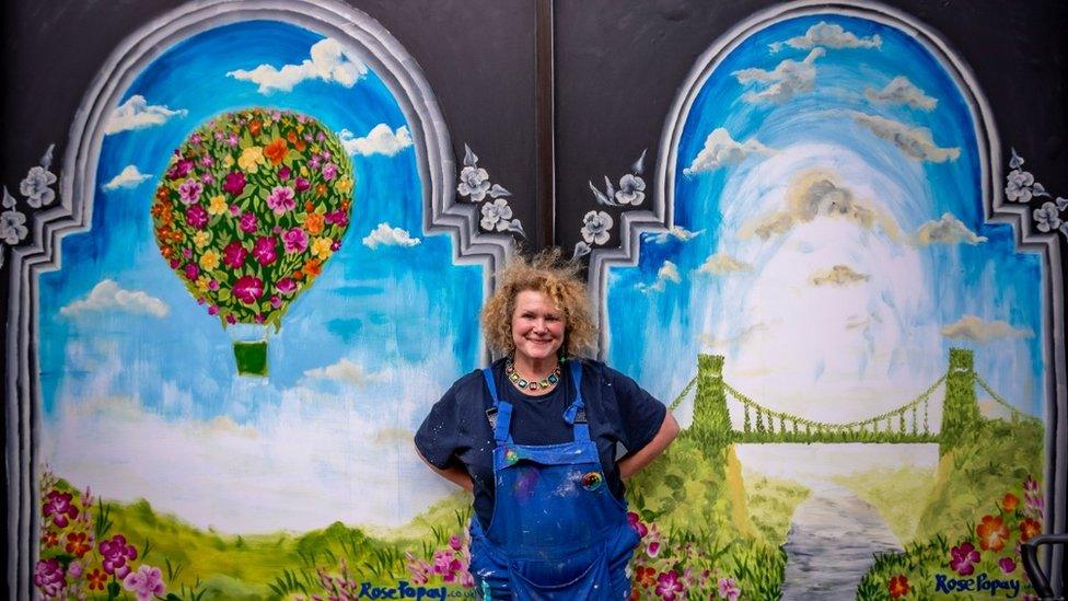 Artist in front of painting of hot air balloon