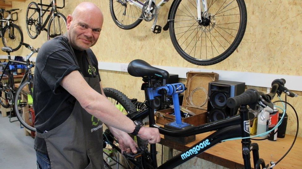 A man repairing a bike in the new facility