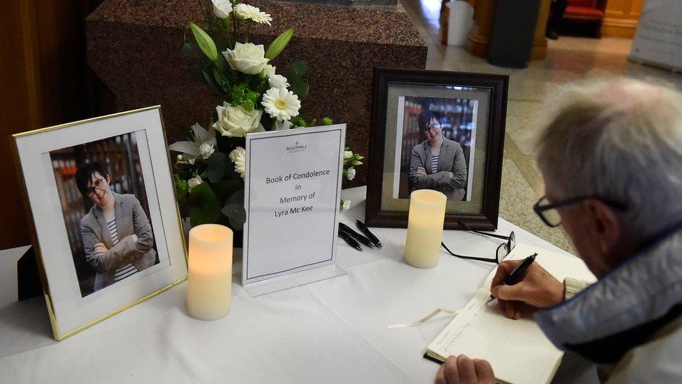 A man signs a book of condolence for Lyra McKee in the Guildhall in Londonderry