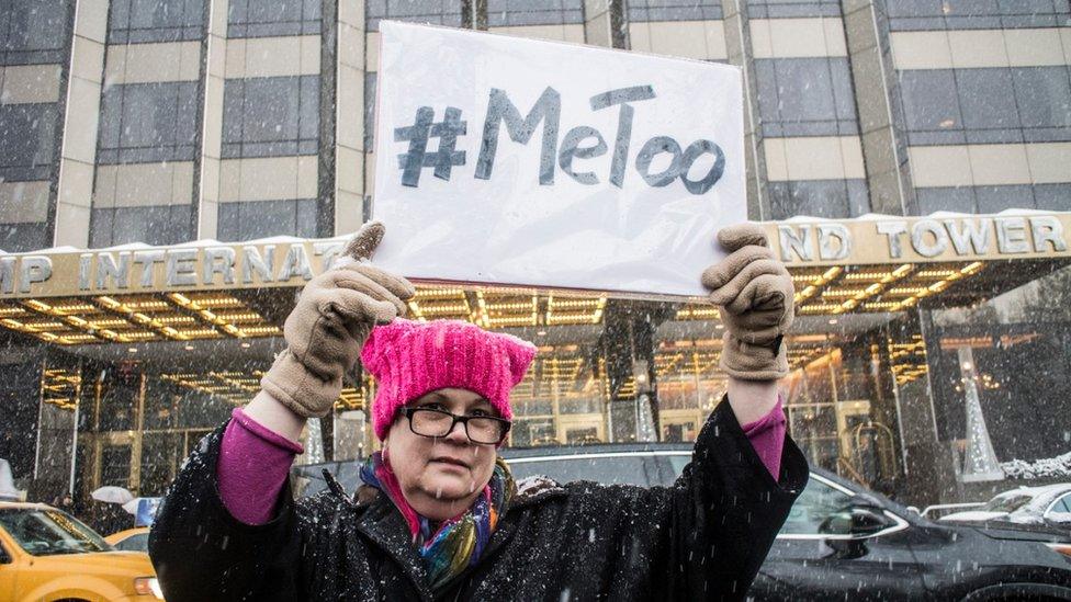 Woman in New York holds aloft a MeToo placard