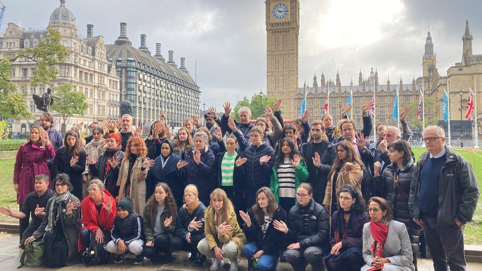 Image showing attendees holding up their hands with the names of dead children on them