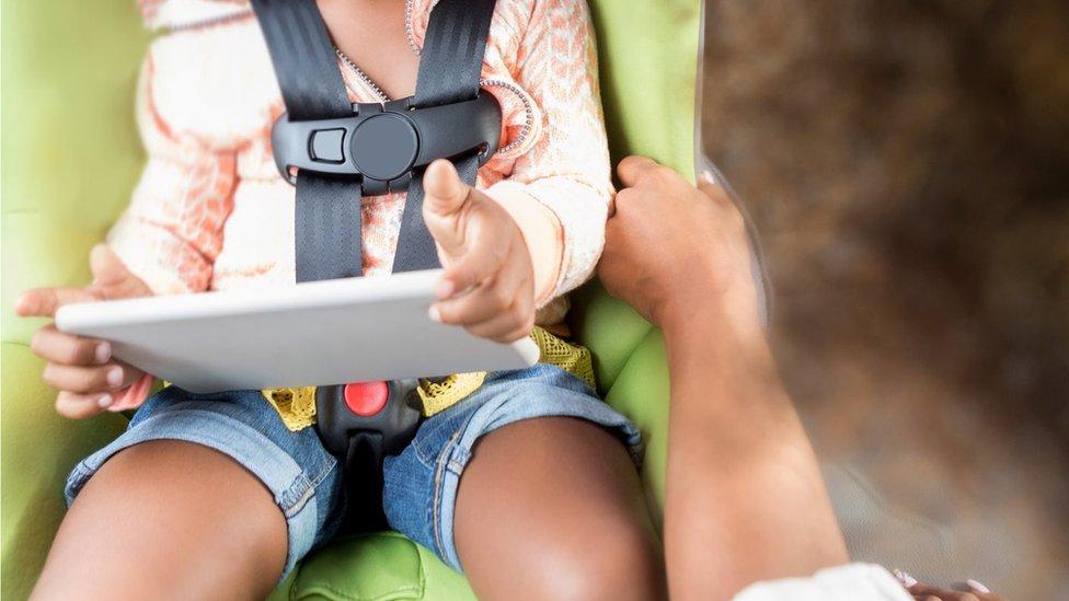 Child in car with tablet