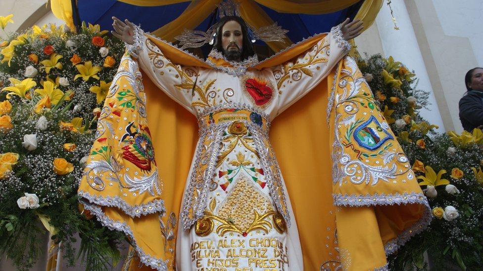 A statue of Jesus Christ surrounded by flowers