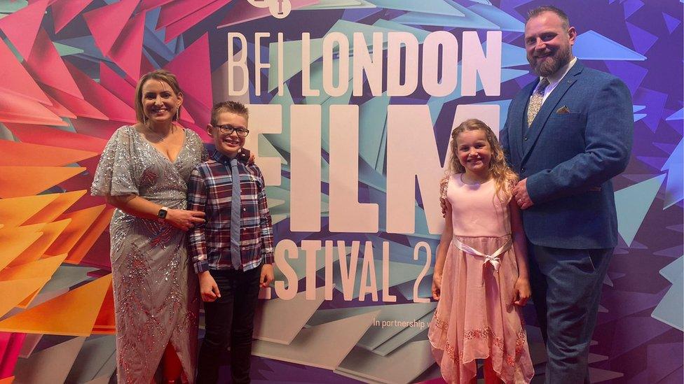 The family in front of a London Film Festival sign