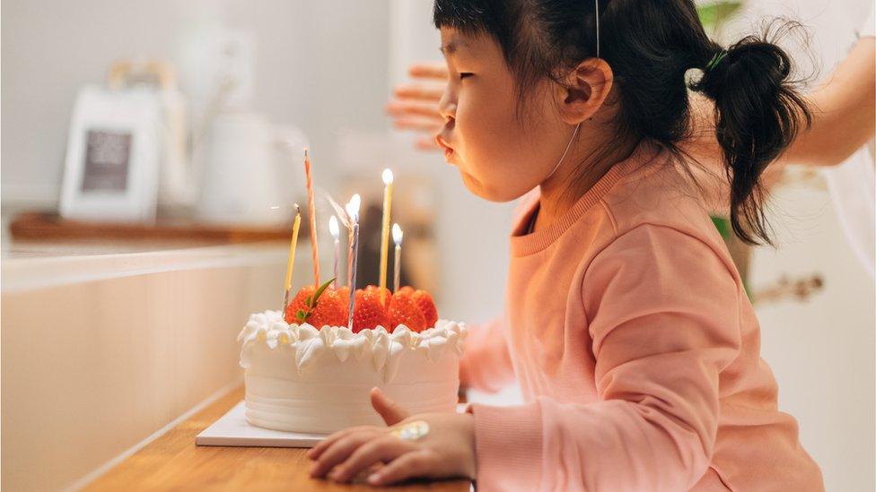 Girl blowing out birthday candles