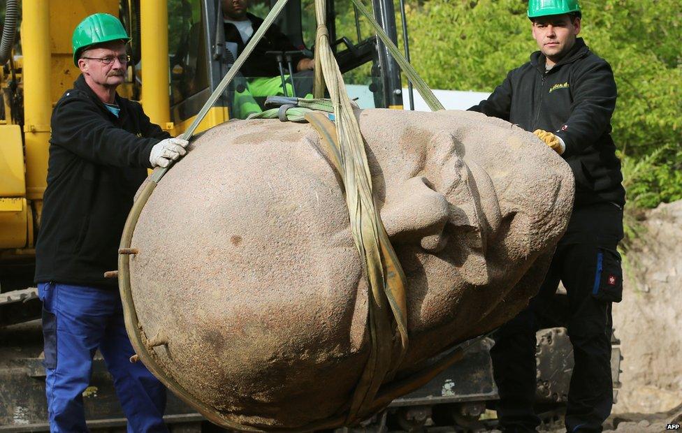 Worker remove the head of a statue of the late Soviet leader Vladimir Ilyich Lenin which was buried in a forest in the east of Berlin on 10 September 2015