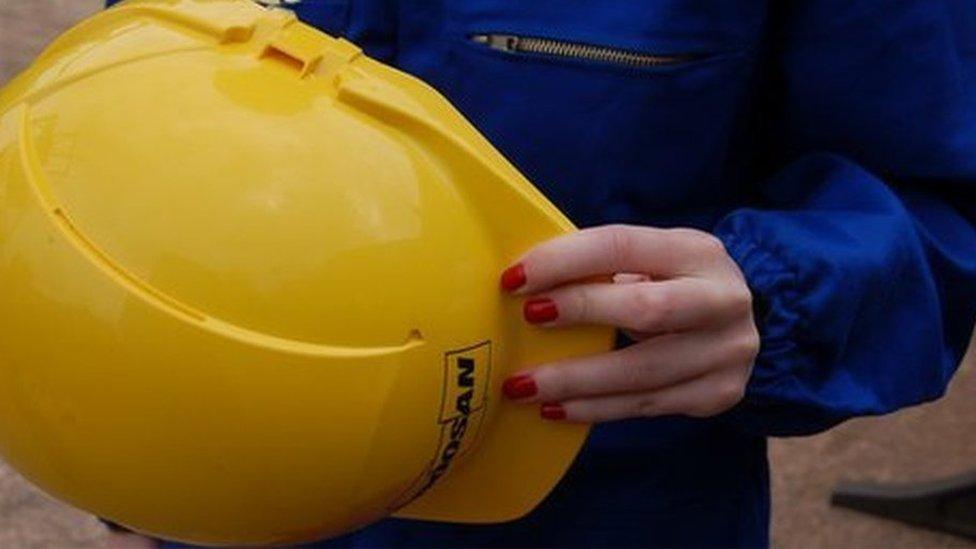 Nail varnished hand with hard hat