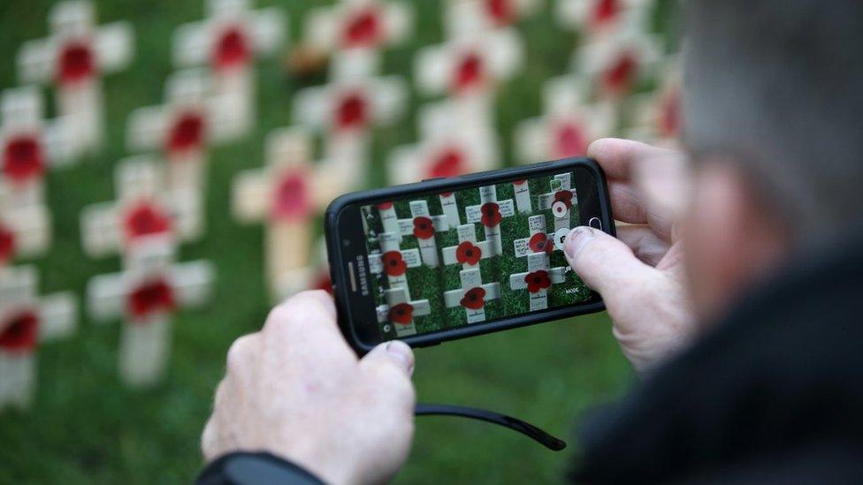 Man takes picture of memorial on phone