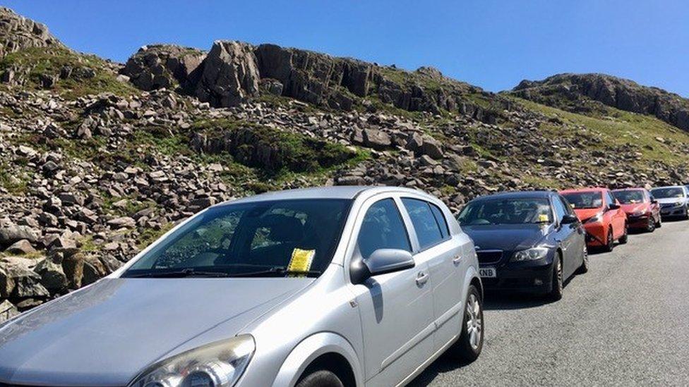 Ceir wedi parcio ar ochr y ffordd ym Mhen y Pass, Llanberis