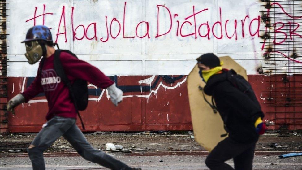 Anti-government activists clash with riot police during a protest in Caracas on July 28, 2017