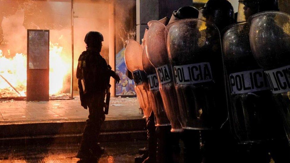 Riot police officers keep watch after clashing with demonstrators when trying to break blockades, as part of a national strike to demand the resignation of authorities from the attorney general's office, in Guatemala City, Guatemala October 9, 2023