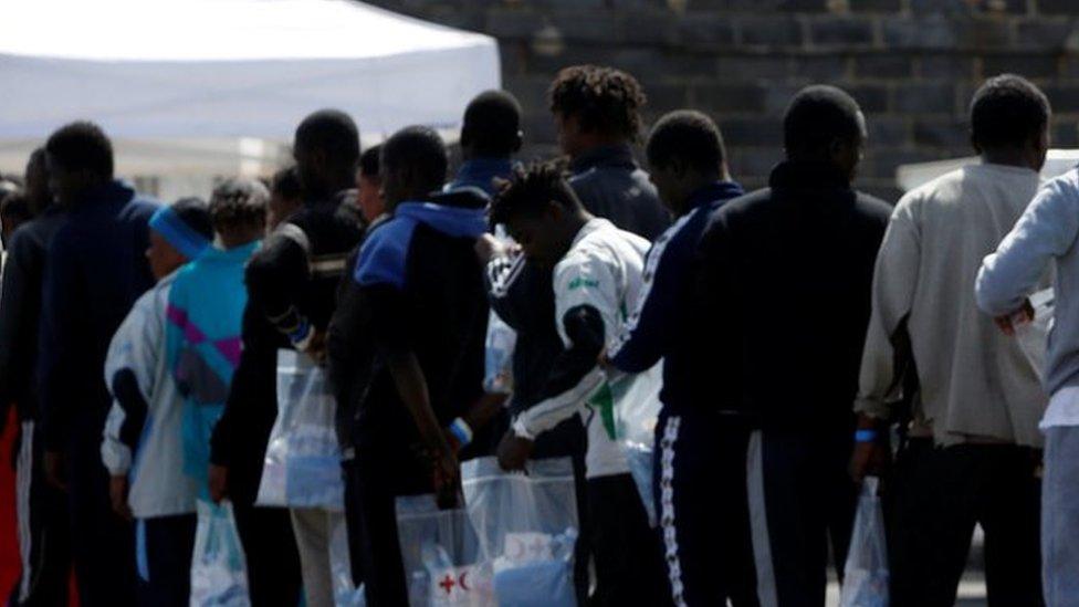 A migrant child plays with a handbag as other migrants queue to be medically checked after disembarking from the Malta-based NGO Migrant Offshore Aid Station (MOAS) ship Phoenix after it arrived with migrants and a corpse on board, in Catania on the island of Sicily, Italy, May 6, 2017