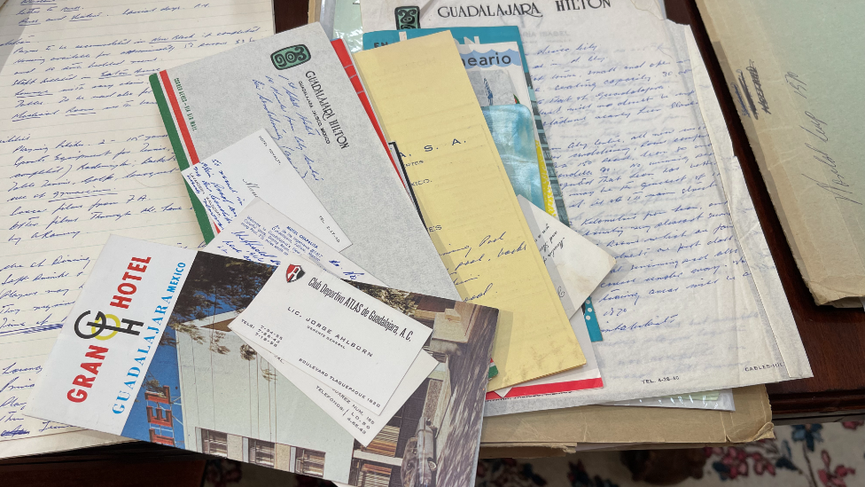 A collection of pieces of paper, documents and business cards spread on a table.