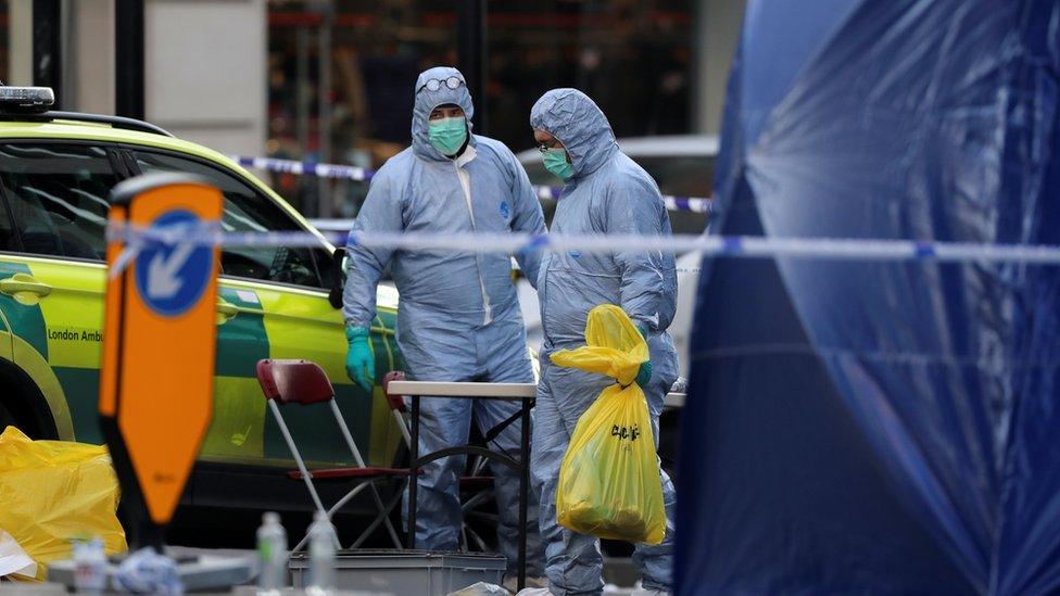 Forensic officers work at the scene of a stabbing on London Bridge