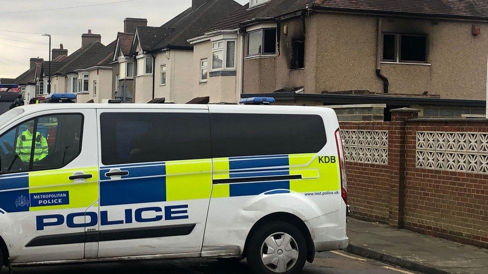 Police van in front of fire damaged house